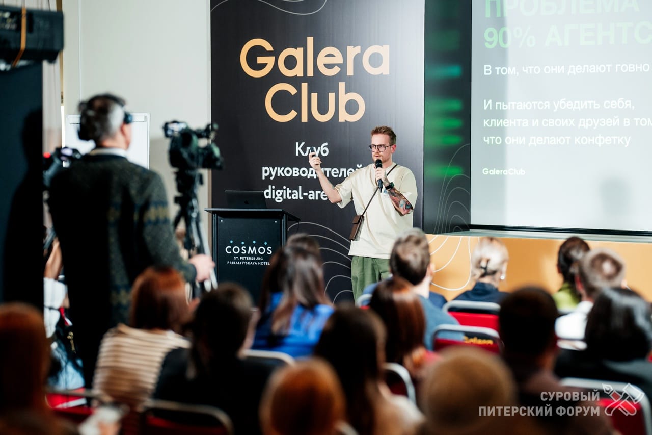 Антон Власов с микрофоном на сцене выступает перед залом — про проджект-менеджера и работу с клиентом